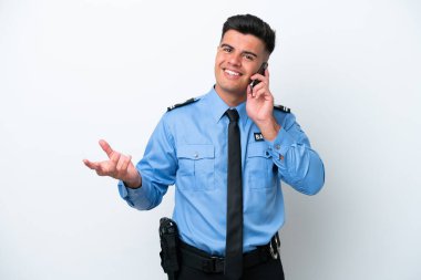 Beyaz arka planda izole edilmiş genç bir beyaz adam cep telefonuyla sohbet ediyor.