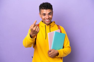 Young student Brazilian man isolated on purple background doing coming gesture