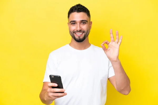 Young Arab Handsome Man Isolated Yellow Background Using Mobile Phone — 스톡 사진