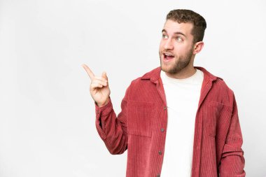 Genç, sarışın, soyutlanmış beyaz arka planda bir parmağını kaldırarak çözümü bulmaya çalışan bir adam.