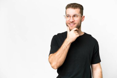 Young handsome blonde man over isolated white background looking to the side and smiling
