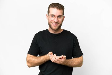 Genç yakışıklı sarışın adam soyutlanmış beyaz arka plan gülüyor.