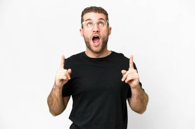 Young handsome blonde man over isolated white background surprised and pointing up
