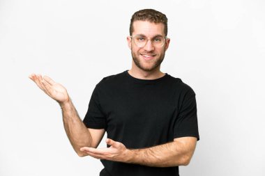 Young handsome blonde man over isolated white background extending hands to the side for inviting to come