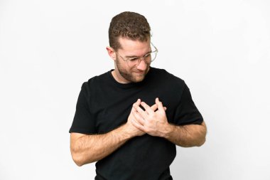 Young handsome blonde man over isolated white background having a pain in the heart
