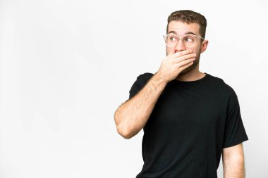 Young handsome blonde man over isolated white background doing surprise gesture while looking to the side