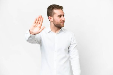 Young handsome blonde man over isolated white background making stop gesture and disappointed