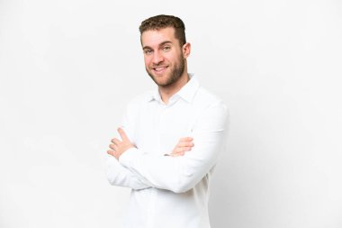 Young handsome blonde man over isolated white background with arms crossed and looking forward