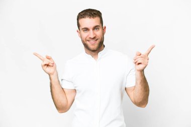 Young handsome blonde man over isolated white background pointing finger to the laterals and happy