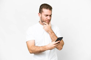 Young handsome blonde man over isolated white background thinking and sending a message