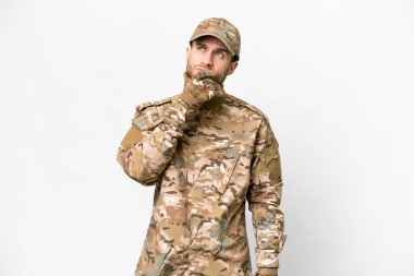 Military man over isolated white background having doubts and with confuse face expression