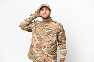 Military man over isolated white background having doubts and with confuse face expression