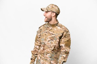 Military man over isolated white background laughing in lateral position