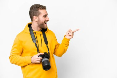 İzole edilmiş beyaz arkaplan üzerinde genç fotoğrafçı parmağını yana uzattı ve bir ürün sundu.