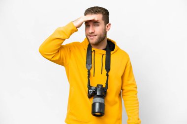 Young photographer man over isolated white background looking far away with hand to look something