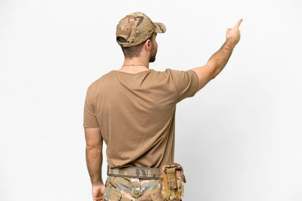 Military with dog tag over isolated white background pointing back with the index finger