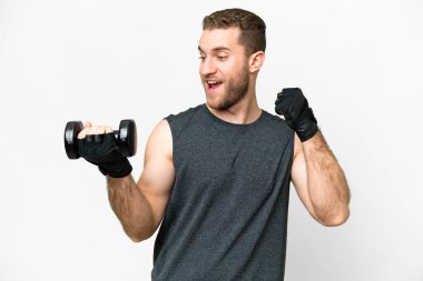 Young sport man making weightlifting over isolated white background celebrating a victory