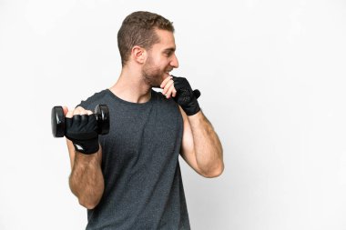 Young sport man making weightlifting over isolated white background thinking an idea and looking side