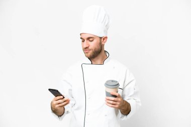 Sarışın genç adam. Şef izole edilmiş beyaz arka plan. Elinde kahve ve cep telefonu var.