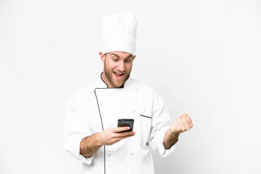 Young blonde man Chef over isolated white background surprised and sending a message