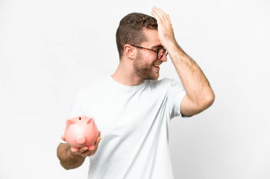 Young handsome blonde man holding a piggybank has realized something and intending the solution