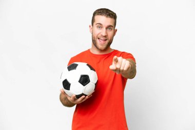 Handsome young football player man over isolated white background surprised and pointing front