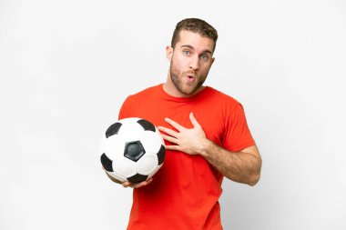 Handsome young football player man over isolated white background surprised and shocked while looking right