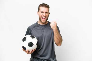 Young handsome blonde man over isolated white background with soccer ball celebrating a victory