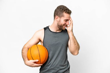 Handsome young man playing basketball over isolated white background laughing