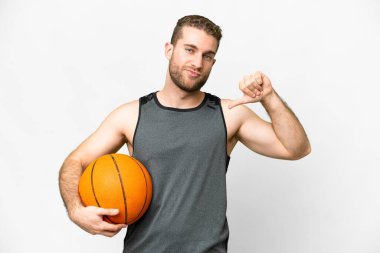 Handsome young man playing basketball over isolated white background proud and self-satisfied