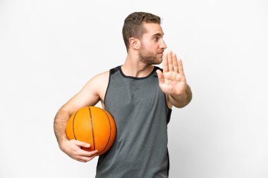 Handsome young man playing basketball over isolated white background making stop gesture and disappointed