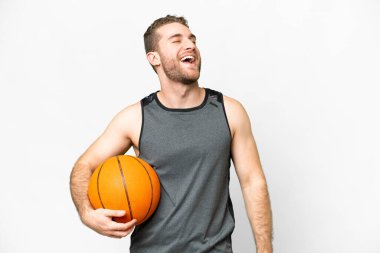 Handsome young man playing basketball over isolated white background laughing