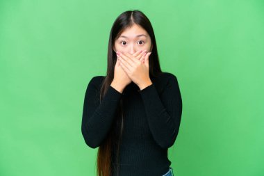 Young Asian woman over isolated chroma key background covering mouth with hands
