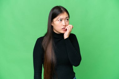 Young Asian woman over isolated chroma key background is a little bit nervous
