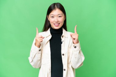 Young Asian woman over isolated chroma key background pointing up a great idea