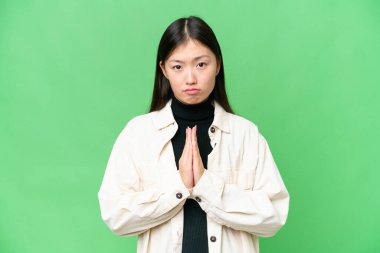 Tecrit edilmiş krom anahtar geçmişi olan genç bir Asyalı kadın avuç içlerini bir arada tutuyor. İnsan bir şey ister.