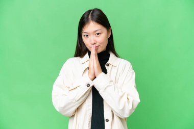 Tecrit edilmiş krom anahtar geçmişi olan genç bir Asyalı kadın avuç içlerini bir arada tutuyor. İnsan bir şey ister.