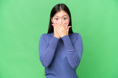 Young Asian woman over isolated chroma key background covering mouth with hands