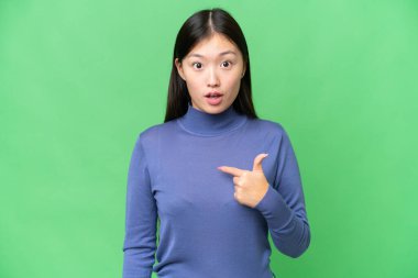 Genç Asyalı kadın izole edilmiş krom anahtar geçmişi kendini işaret ediyor.