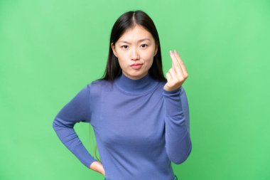 Young Asian woman over isolated chroma key background making Italian gesture