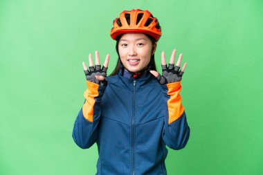 Young cyclist woman over isolated chroma key background counting nine with fingers