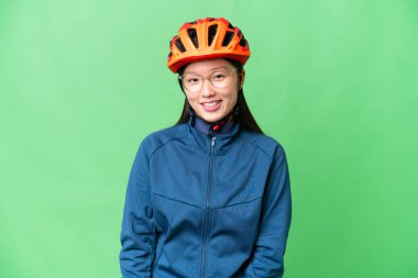 Young cyclist woman over isolated chroma key background with glasses and happy