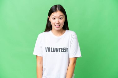 Yüzünde sürpriz ifade olan izole edilmiş krom anahtar geçmişi olan genç gönüllü bir kadın.