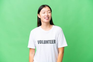 Genç gönüllü kadın izole edilmiş krom anahtar arka planı gülüyor.