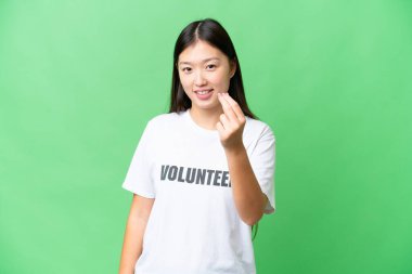 Young volunteer woman over isolated chroma key background making money gesture