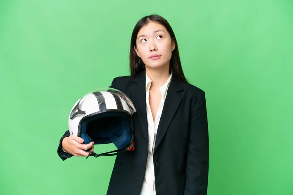 若いですアジアの女性とともにオートバイヘルメット上の隔離されたクロマキー背景と見上げます — ストック写真