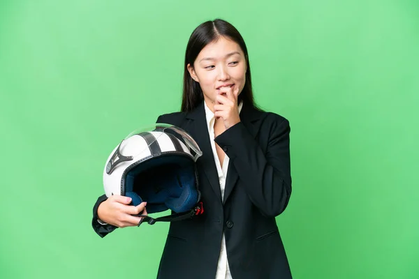 若いですアジアの女性とともにオートバイヘルメット上の隔離されたクロマキー背景見ますザ側と笑顔 — ストック写真