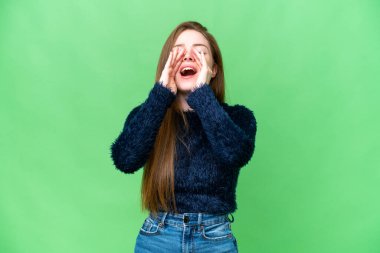 Genç ve güzel bir kadın izole edilmiş krom anahtar arka planda bağırıyor ve bir şey duyuruyor.