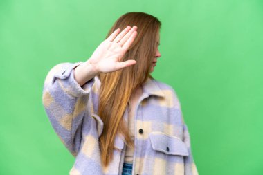 Young pretty woman over isolated chroma key background making stop gesture and disappointed