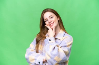 Genç ve güzel bir kadın izole edilmiş krom anahtar arka planı mutlu ve gülümsüyor.